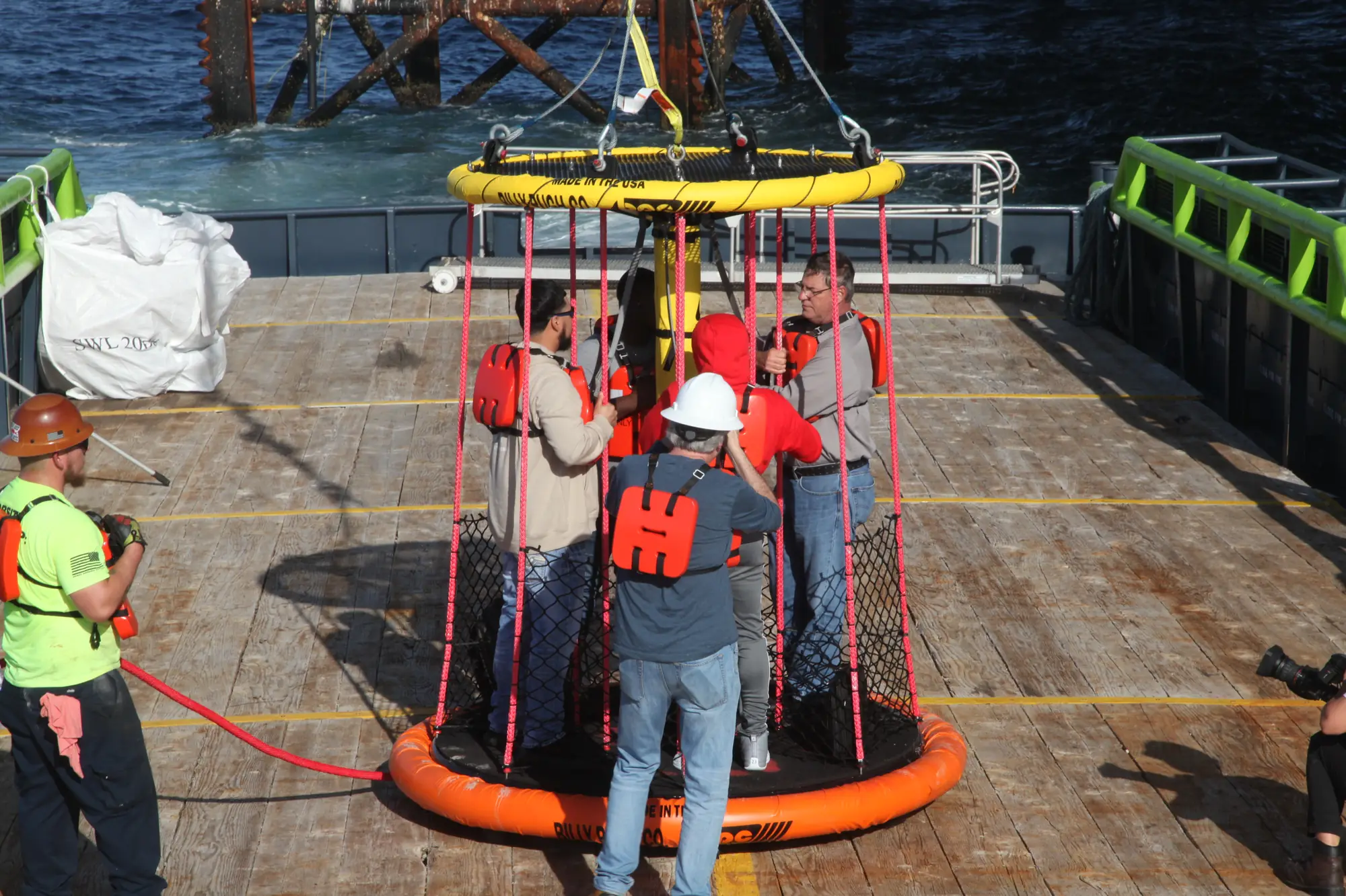 Crew riding an X-904 personnel transfer device on the deck of an offshore supply vessel